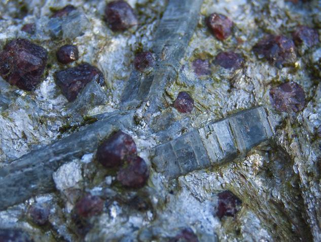 27 MINERALSTUDIE ein bergart består som oftast av fleire typar mineral. På bergflata her, som består av granatglimmerskifer, ser vi fine eksemplar av muskovitt, granat, kyanitt og kvarts.