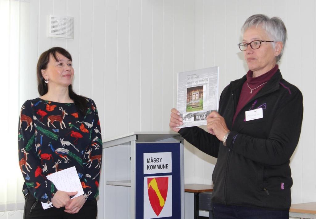 Ordfører Reidunn Mortensen takkes med «Utedoboka» av leder for Troms historielag, Arnhild Lindholm.