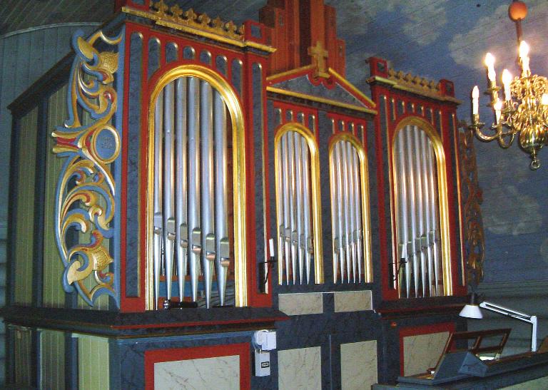 Derfor ble det festet skårne ornamenter, lik dem som omkranser altertavla, på orgelet i 1922. (Foto: forfatteren). det solgt til Folldal kirke. Den 12.