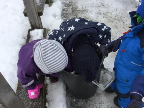 Her har Kjell og 2 åringene tatt saken i egne hender ut å strø Sand må hentes i bøtte utenfor gjerdet og strøas rundt om i barnehagen slik at