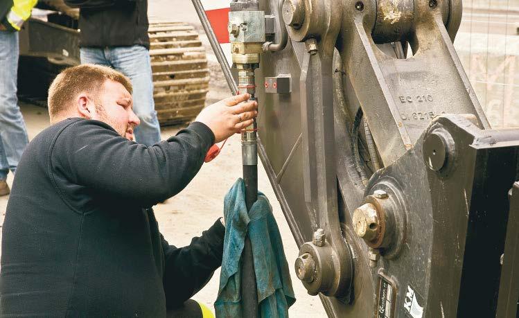 Maskinfører Kim Nielsen kobler NPK-aggregatets hydraulikkslange til hammerhydraulikken på Volvo EC210.