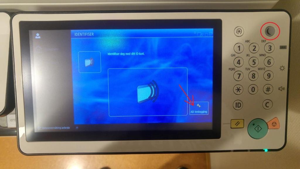 6. På skriveren, trykk på «AD Innlogging». Dersom skjermen er svart har skriveren gått i hvilemodus.