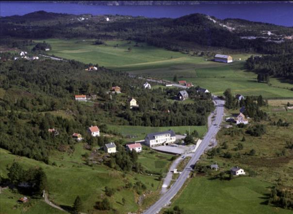 Figur 6. Flyfoto fra 1961, med Haukås skole foran og Haukås gård med de oppdyrkete Haukåsmyrene i bakgrunnen (Foto: Fjellanger Widerøe).