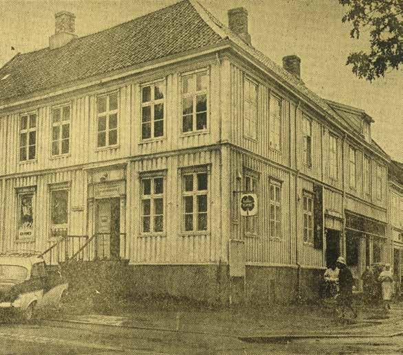 Bildet er antakelig tatt i 1970. Det viser den opprinnelige Lykkegården på hjørnet av Munkegata og Dronningens gate (Munkegata 48), en to etasjes laftet og panelt tregård, som I.K.