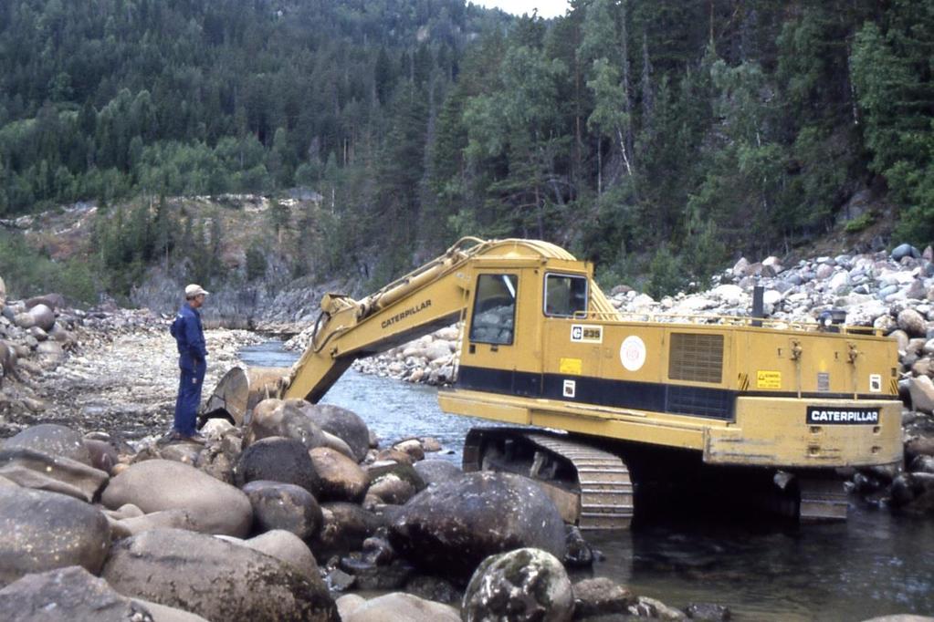 Regulanten gjer utretting og senking av elveløp nedanfor Åmøte-Bruhylen i 1986 med 70 tonns gravemaskin.