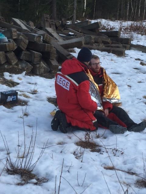 En pasient ligger på veien og den andre pasient sitter på veien, begge er dårlig kledd. Den liggende pasienten har brudd i en hofte og den sittende har pustevansker og har brudd i brystbenet.