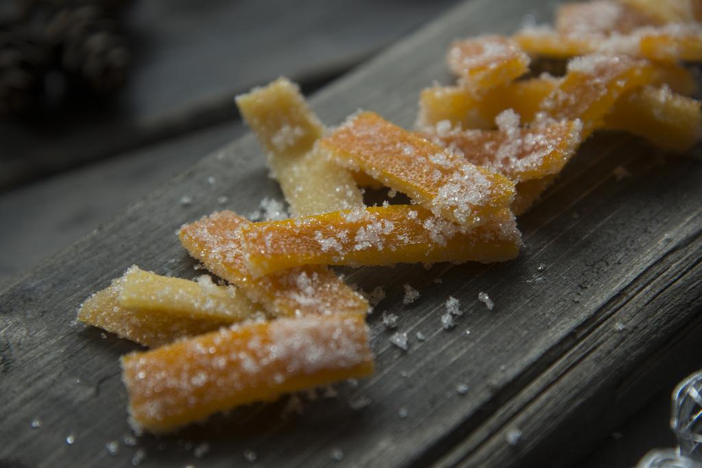 Kandiserte appelsinskall Kandiserte appelsinskall 5 stk appelsiner 400 g sukker 4 dl vann Vann til koking av appelsinskall Del appelsinene i to og skjær ut fruktkjøttet.