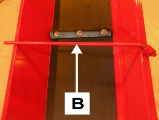 Hold låsen A åpen, og senk ned utmatingstransportøren til laveste posisjon med en