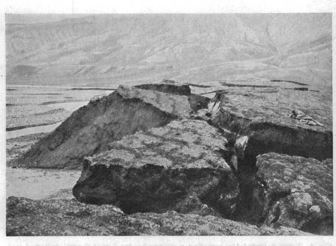 10 [303J Flg. 6. Elvepartl oppe 1 Advent.dalen ved utløpet av Helvetladalen. Elven har gravet under elvebrinken 1 ren Is, som sees i sprekken. Johannes Lid fot. u17 1924.