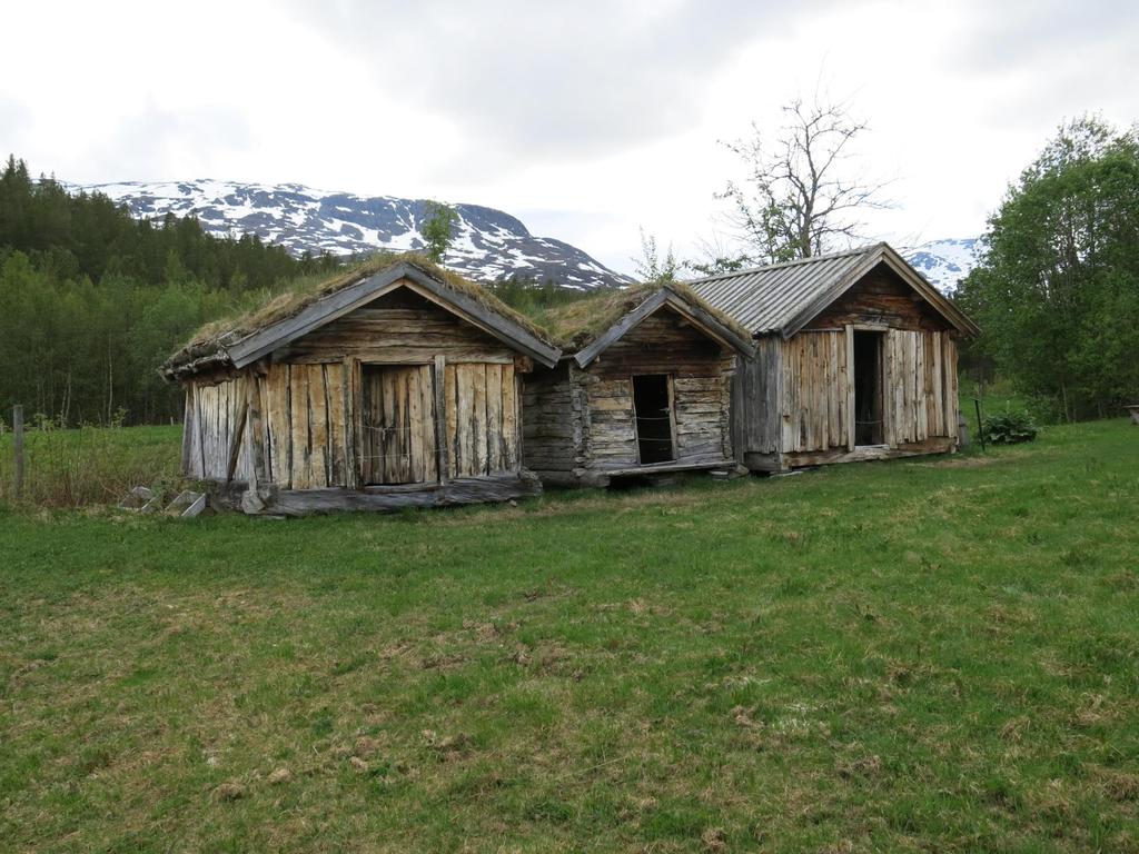 De tre buene ligger på rekke med gavlen og døra inn mot tunet slik det var vanlig i både kvensk og samisk byggeskikk i Nord Troms.