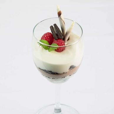 Oreodrøm oreokake anrettet i glass med hjemmelaget phildalephiakrem, bringebær og sitronmelisse (1, 3, 6, 7).