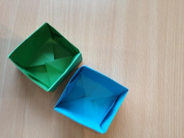 Post 5 Brette origamiboks Fortelle barna at boksen de brette skal brukes til å ha kjeks i som de baker på en annen post. Origamiark, instruksjon.