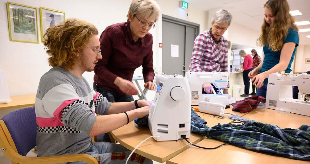 Grønn spalte Zakarias Orrall og Vigdis Neby får hjelp med symaskinene på Fikselauget til Ås husflidslag av Ingeborg Hauge Høyland og Guri Sæther.