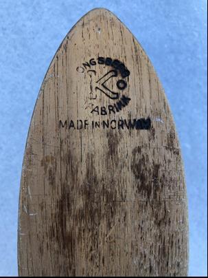 Kongsberg. Skien har ingen merker på oversålen, men logoen er svidd inn i på undersiden av skituppen. Legg merke til skiens design.