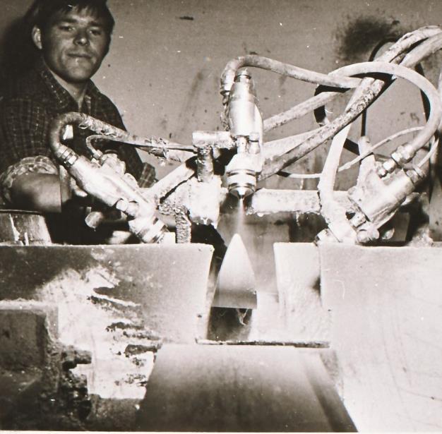 Harald Ulland med lakkeringsautomaten som var i bruk til den den ble skiftet ut med en såkalt «lakkteppemaskin». Teppemaskinen reduserte svinnet av lakk betydelig, men var ikke like produktiv.