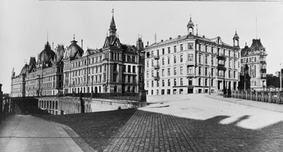 Samtidig rettar bygningen seg etter høgde og form på kvartalet det står inntil, som blei bygd i 1884-1890. Fasaden har stramme, vertikale proporsjoner.