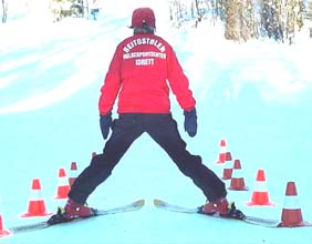 Et bra tips er å la utøveren bruke stavene til å støtte seg på, når de skal vende skiene ned mot fallinjen.