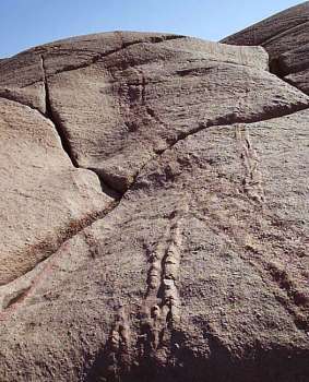 SIGDBRUDD OG SKURINGSSTRIPER: På denne lokaliteten er det synlig noen halvmåneformede groper i fjellet. Disse gropene kalles sigdbrudd og er lagd av kampesteiner som har ligget inne i isbreen.