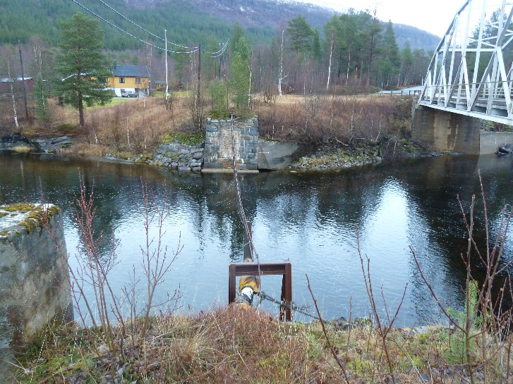 16 Krokstrand Ranaelv forbi Krokstrand er slak med en helning på 0.4 % forbi brua, se figur 14 og 15. Det er et stryk 300 m opp for brua som kan sees på figur 14. Hastigheten avtar ned mot brua.