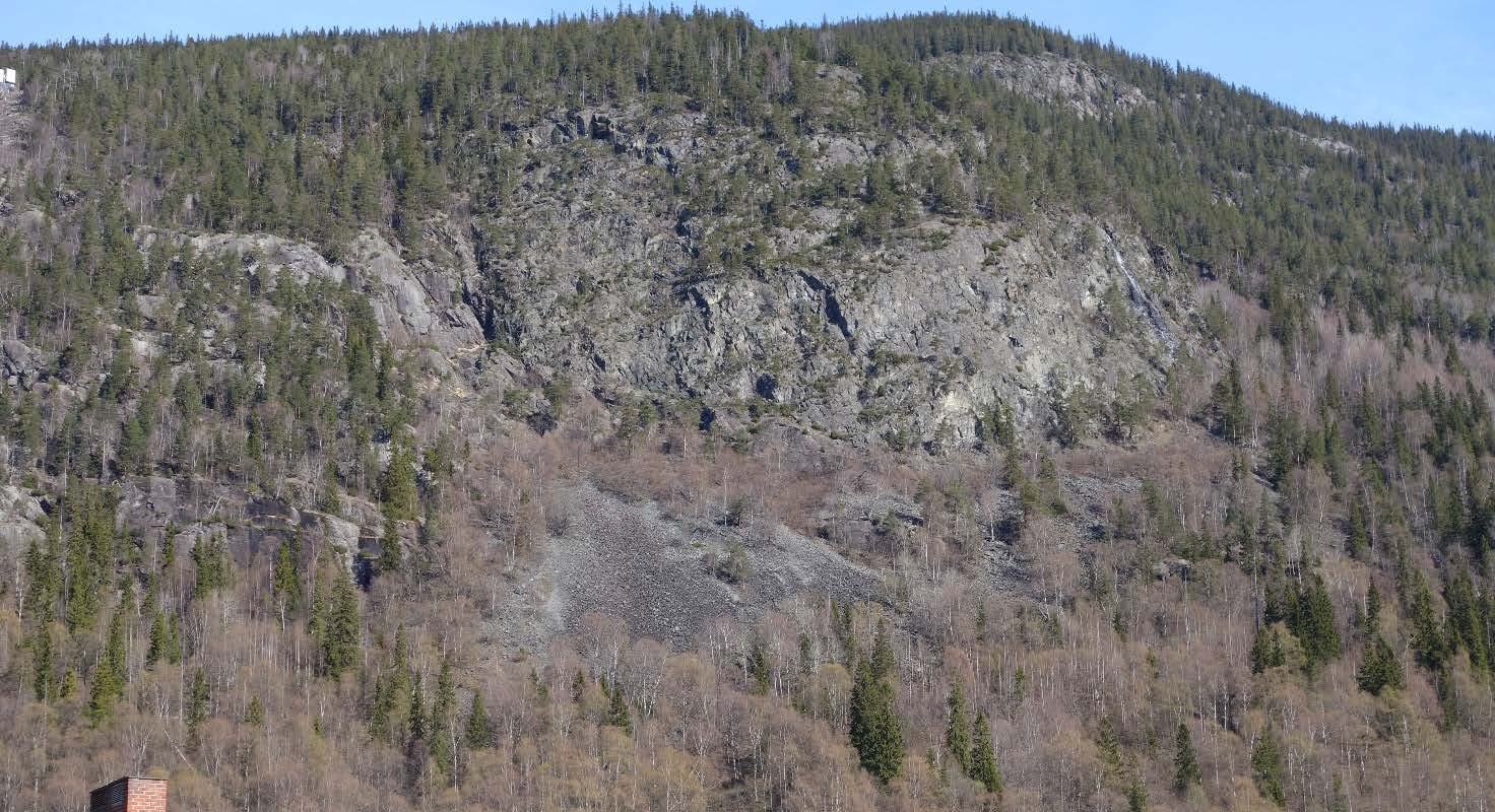 Vedlegg A, side: 4 Foto 5: Detalj fra fjellsiden under solspeilet. Med kikkert kan en se oppsprukne steder hvor utfall kan forekomme.