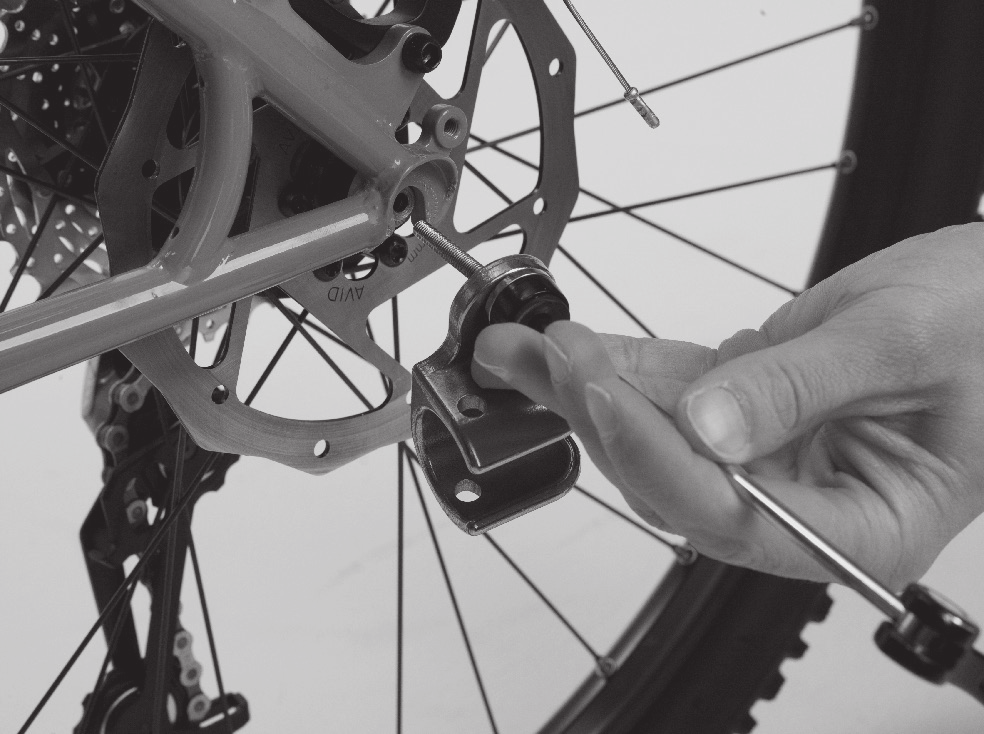 Sett inn hurtigutløserspindelen i akselen på sykkelen fra venstre side pekende til høyre. F. Sett fjæren på plass på hurtigutløserspindelen igjen slik at den smale enden peker innover mot sykkelen.