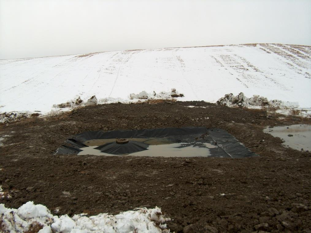 Løsningen går ut på å grave en grunn sedimentasjonsdam rundt kummen, eller på oversiden av kummen, med tett bunnmembran i bunnen av dammen.