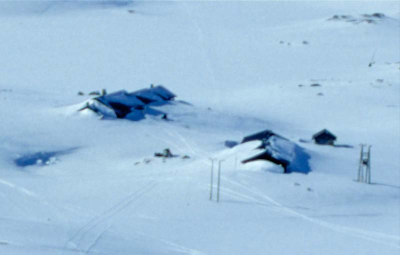 Figur 3.2.2.3 Finse forskningssenter vinterstid, bildet er tatt mot sørvest. Kartet viser de to bygningene samt framherskende vindretning vinterstid. Kart: Norgesglasset.