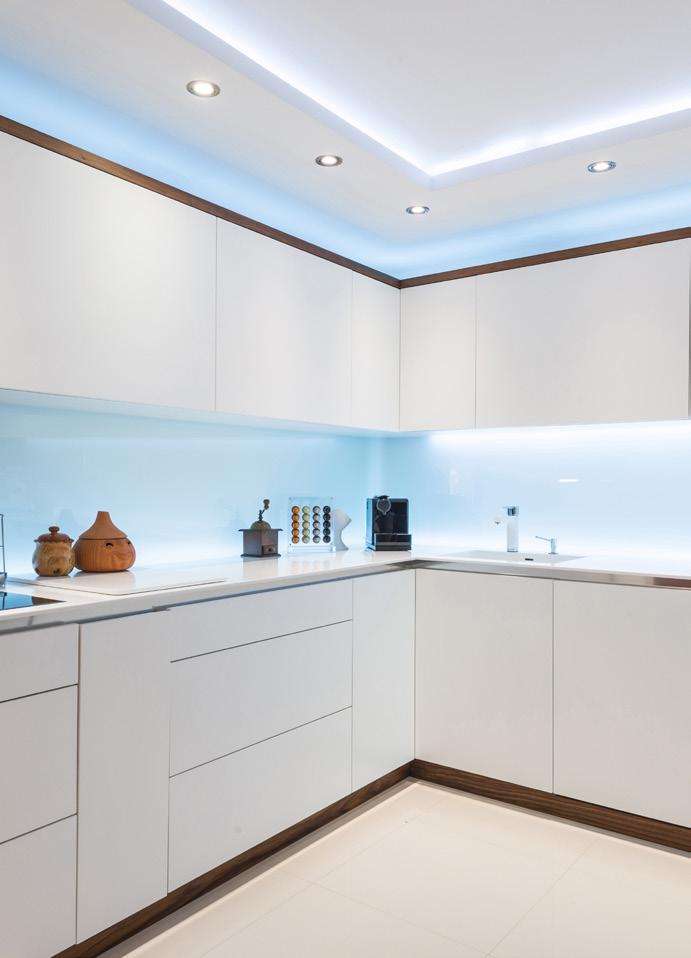Slepelys langs gulvet på kjøkkenet ved å plassere LED strip under kjøkkenskapene gir en elegant touch.