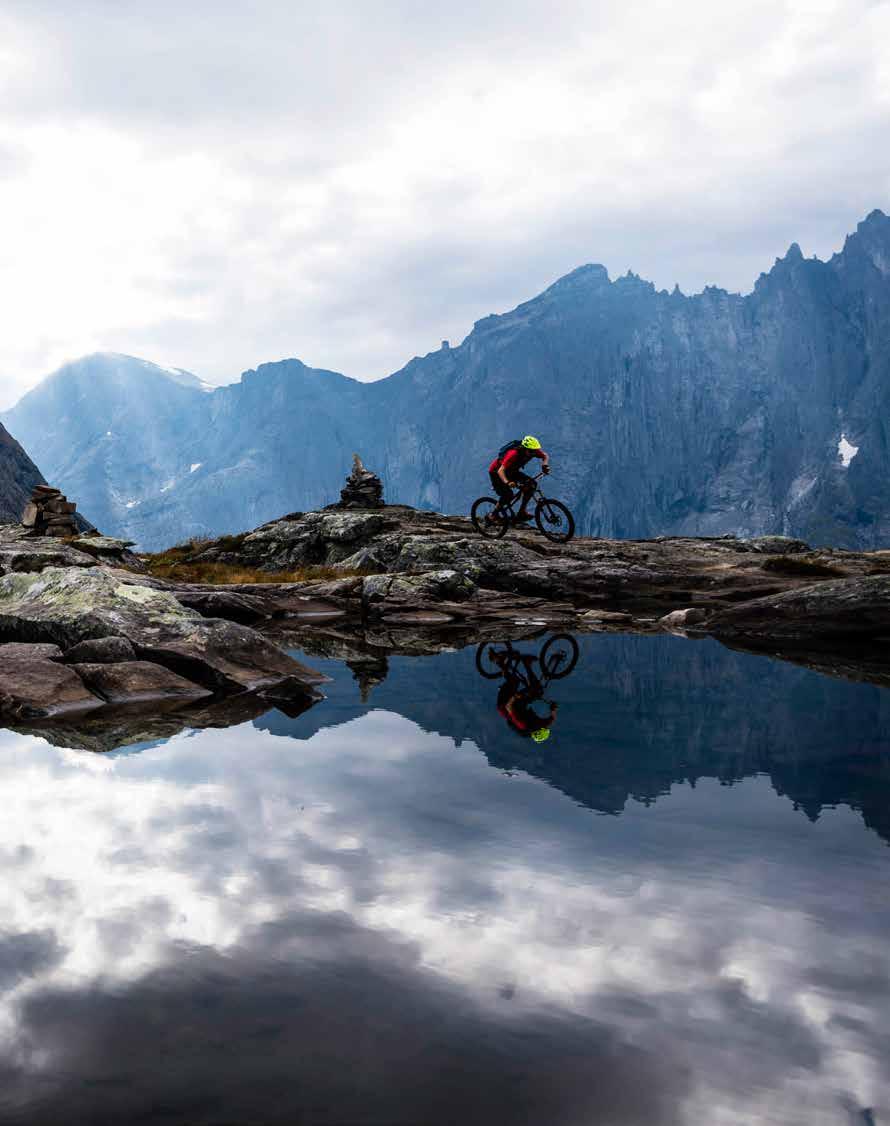 Janne Tjärnström sykler på Litjefjellet mens Romsdalshorn og Trollveggen