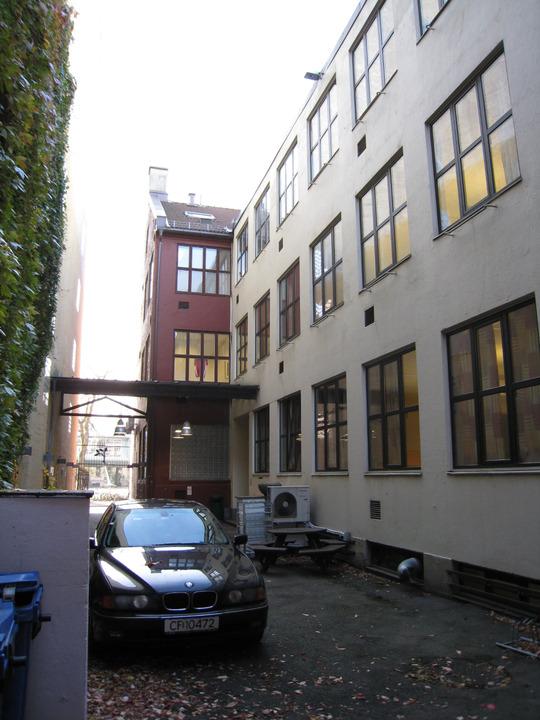 Bakgård med tilbygg og frontbygningens bakside.