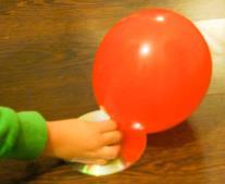 Надујте балон, тако што га прво поставите на затварач, а потом га кроз отвор на ЦД-у надувате.