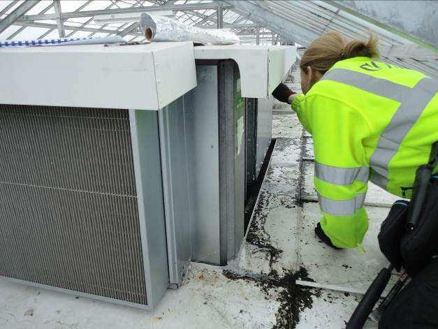 Bilde 20 viser prøvetaking av myk, grå fugemasse på ventilasjonsanlegg på tak på