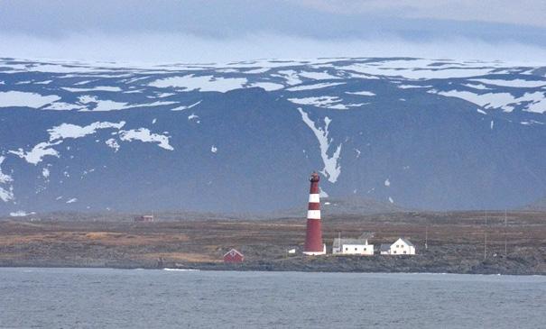 Slettnes fyr fra hurtigruta Foto: Jens-Einar Johansen 22.mai 2016 Været som ventet oss ute på Slettnes fyr denne morgenen var liten østlig kuling og regnbyger. Vi fant le bak fyret.