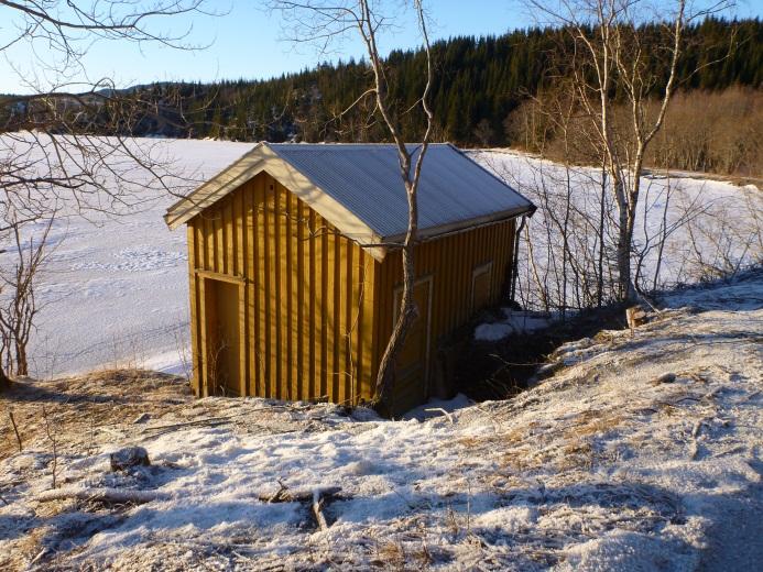 Figur 6 Bygg 3, fasade mot øst. Garasjen mellom bygg 1 og 2 ble satt opp i 1959 og har reisverk av tre med kledning av eternittplater. Figur 7 Garasjen, åpning mot øst.