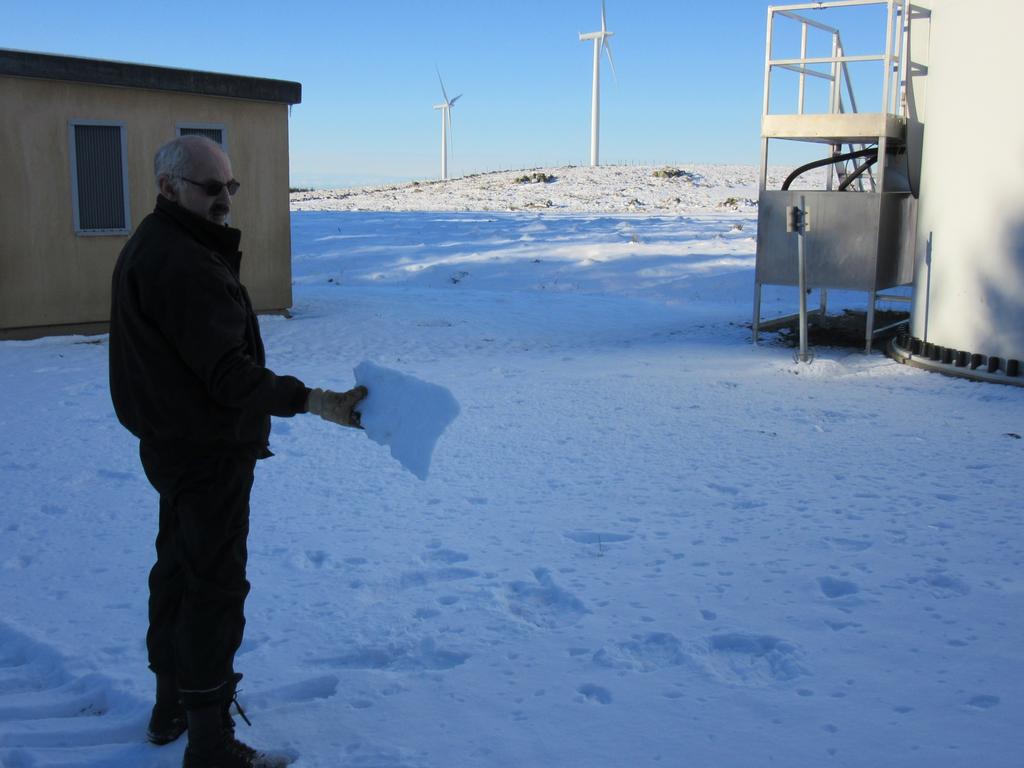 Merk hvordan små og store isklumper har regnet ned i snøen rundt vindturbinen.
