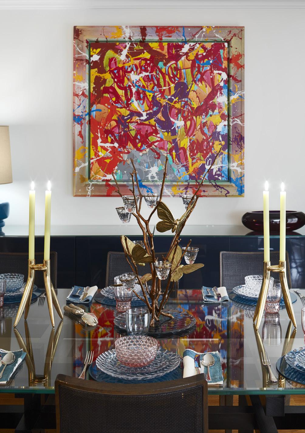 VENSTRE Spisebordet er dekket med en glassplate og dekorert med en kandelaber av den franske kunstneren Joy de Rohan Chabot og Philippe Starcks mer strømlinjeformede lysestaker.