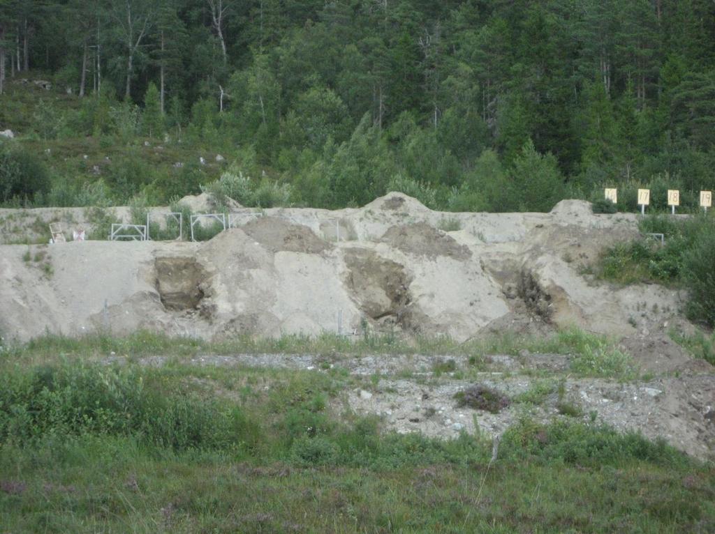 Figur 4. Foto som viser utgravde sjakter i fremre kulefangervoll ved Gurulia SØF. I den bakre kulefangervollen ble sjaktene gravd ca 3 meter inn i vollen til ca 2 meters dyp sett ovenfra.