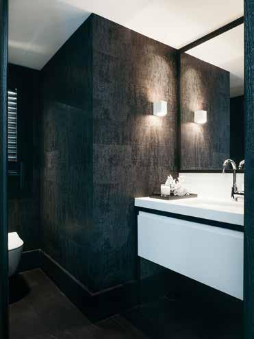 Rustikt badeværelse med sorte veggfliser og hvite baderomsskap