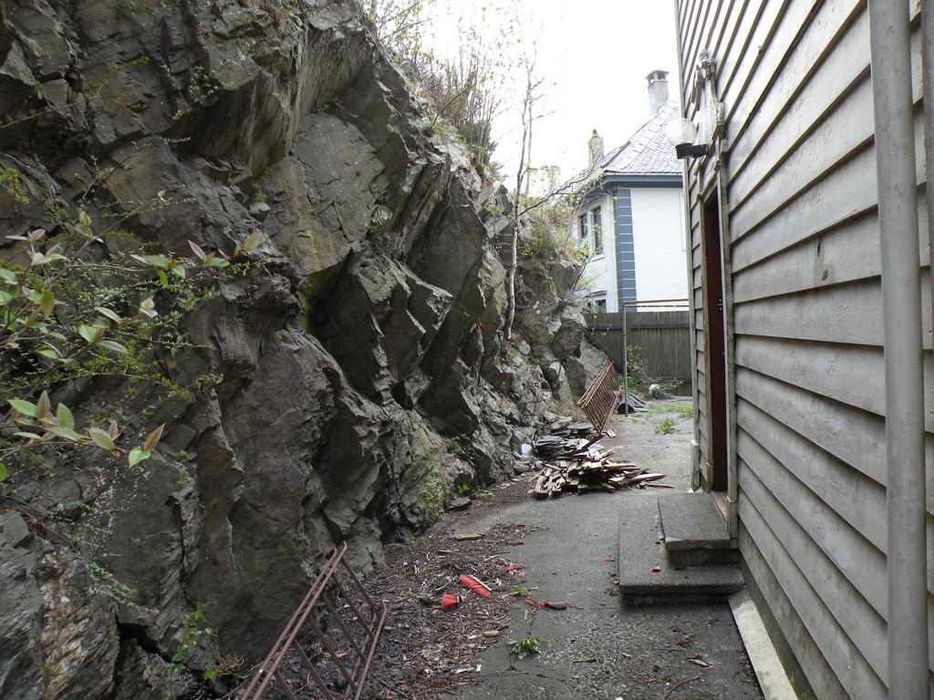 ut. Ved hus nr 10 er det brattest her er skråningen vertikal og ca 4-5 meter høy før den blir slakere opp mot naboeiendommen, se teknisk kart figur 1.