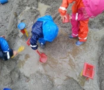 Til dømes kan vi i sandkassen når det regnar laga demningar og kanalar. I samtale med barna kring dette kan vi introdusera dei for nye ord og omgrep, som demning og kva funksjon denne har.