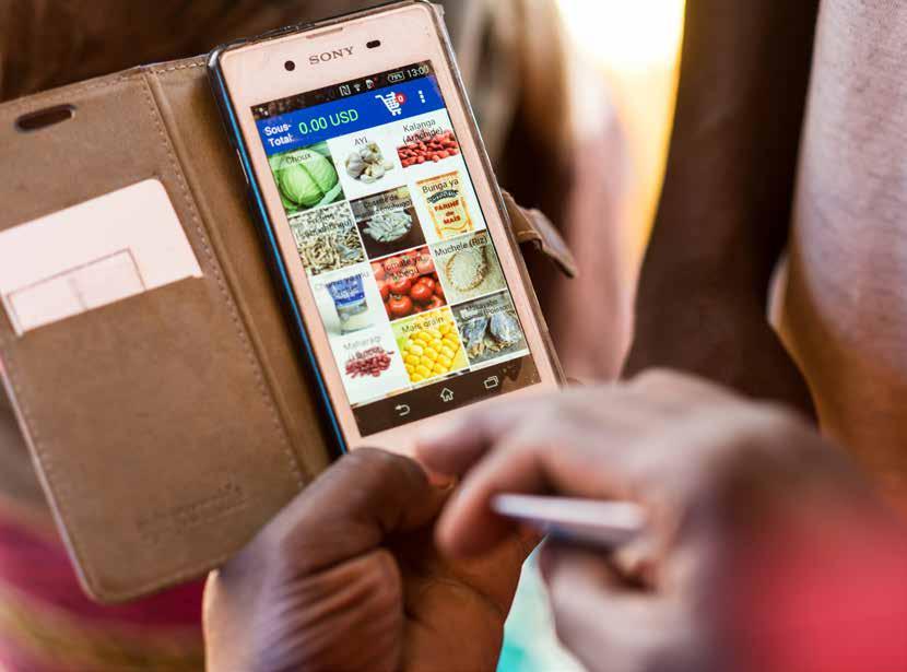 6 313 familier mottar mat og husholdningsartikler med elektroniske kuponger på markedet i Kanyabayonga, Den demokratiske republikken Kongo.