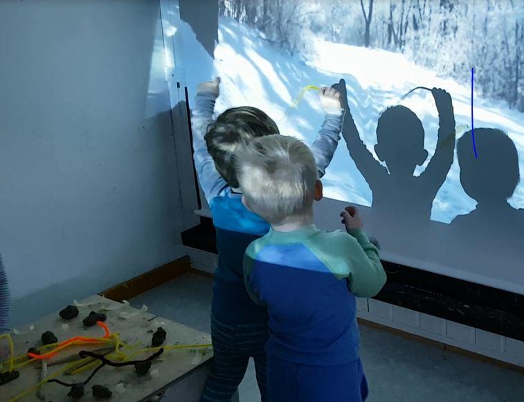 Vi lar prosjektoren sende ulike vinterbilder på veggene og barna har oppdaget at de blir en bevegelig del av bildene