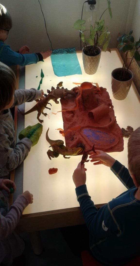 Under er det lek med dinosaurer og vulkan, og selvlagede haier av plastelina på bildet nummer 2. Begge lekene finner sted på lysbordet.