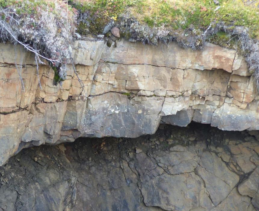 Bilde 9: Bergarten basalkonglomerat ligger blottet stratigrafisk over grunnfjellet ved en foss i nedre del av Geatkejohka. Fagområde: Stratigrafi og paleomiljø.