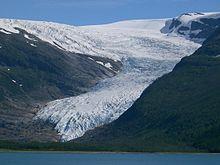 Figur 2: Her ser vi brefronten til Engabreen, Svartisen i Nordland. Bildet viser den plastiske egenskaper der isen flyter som en sakteflytende væske ned dalen. Foto: Wikipedia.