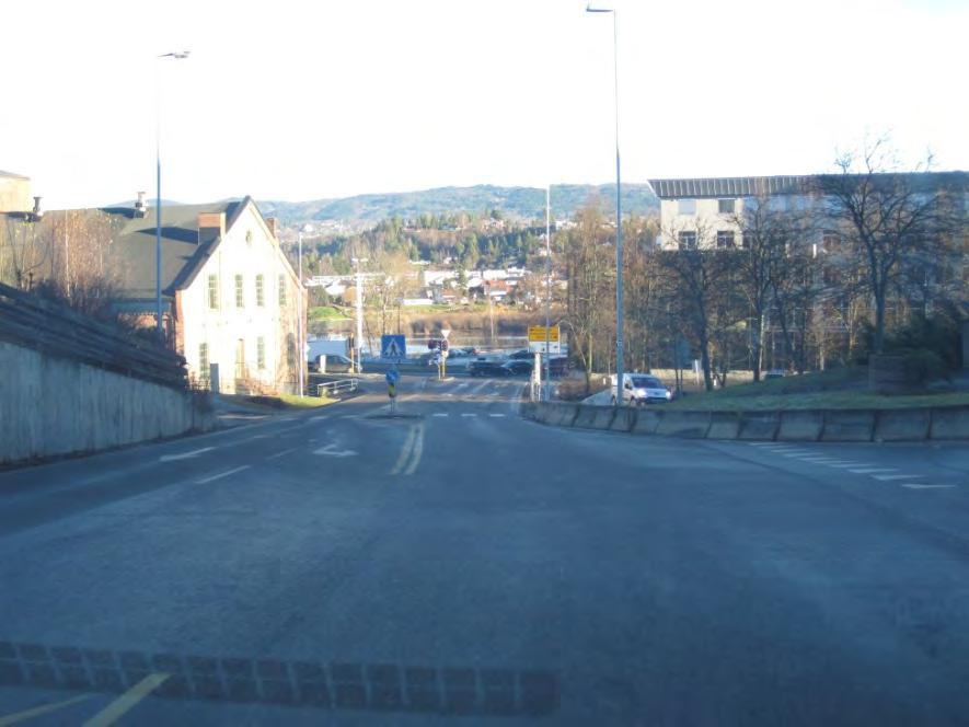 Skiltet fart er 50km/t. Det ligger et venstresvingefelt i Arnemannsveien for de som skal kjøre av til Fossvegen og dagens parkeringsplass på Brutorget.