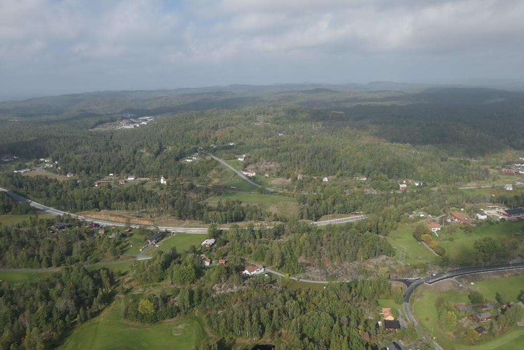 Figur 5-10: Fosseskjæra i forgrunnen med jernbanelinja til venstre i bildet. Eksisterende E18 krysser Farsjø på bro midt i bildet.
