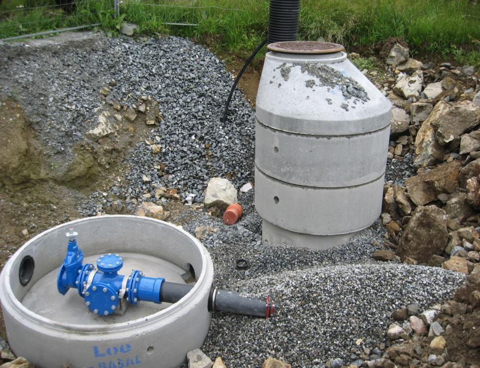 Bildet viser en ferdig vannkum, samt en vannkum under bygging der det er montert en ledning med stoppekran.