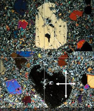 Gruppen av avlange krystaller i midten av bildet viser forskjellige nyanser av brun farge selv om de alle er samme mineral. (2 poeng hver) a) Hvorfor har de forskjellige nyanser av brun farge?